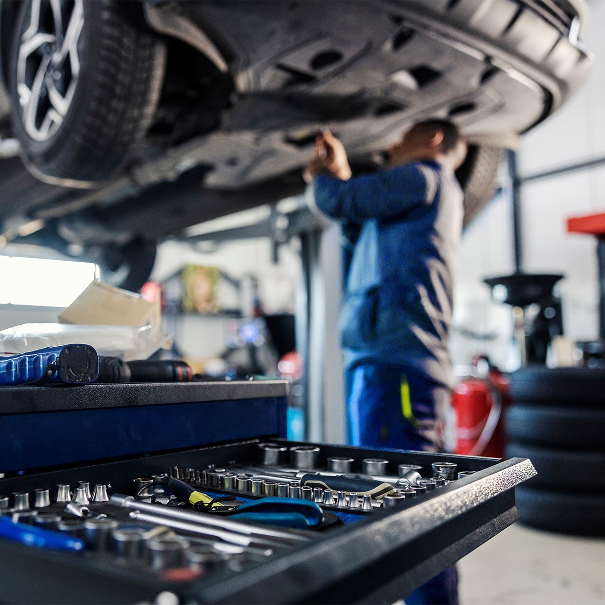 man fixing car in background